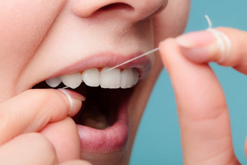 Trồng răng sứ bị đen chân răng: Nguyên nhân và cách khắc phục Sử dụng chỉ nha khoa để loại bỏ sạch cặn thức ăn trên răng